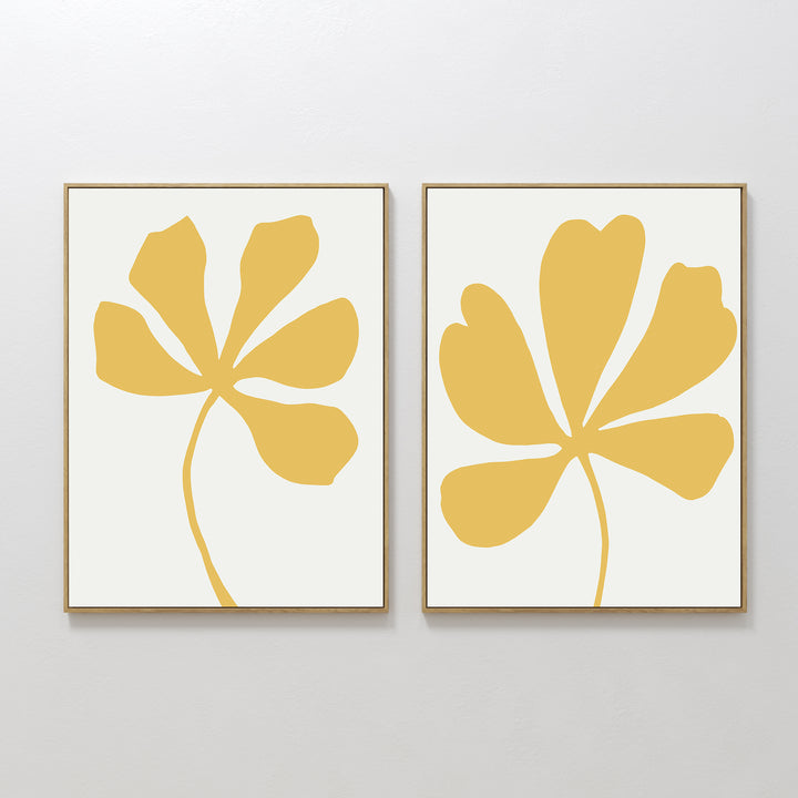 The Sunleaf Silhouettes Set of 2 features minimalist wall art with abstract yellow floral designs on white backgrounds—ideal as large, contemporary prints to enhance any modern space.