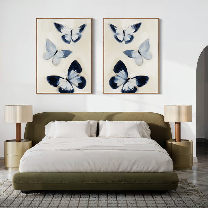 A modern bedroom features an olive-green upholstered bed, white bedding, round gold nightstands with ribbed lamps, and the Midnight Wings Set of 2 butterfly wall art above the bed for a touch of Nordic Park-inspired decor.