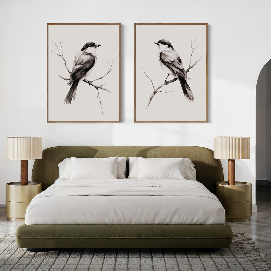A modern bedroom with a green upholstered bed, neutral bedding, two round nightstands and lamps, plus striking Still Perch Set of 2 bird art prints from Nordic Park displayed above the headboard.