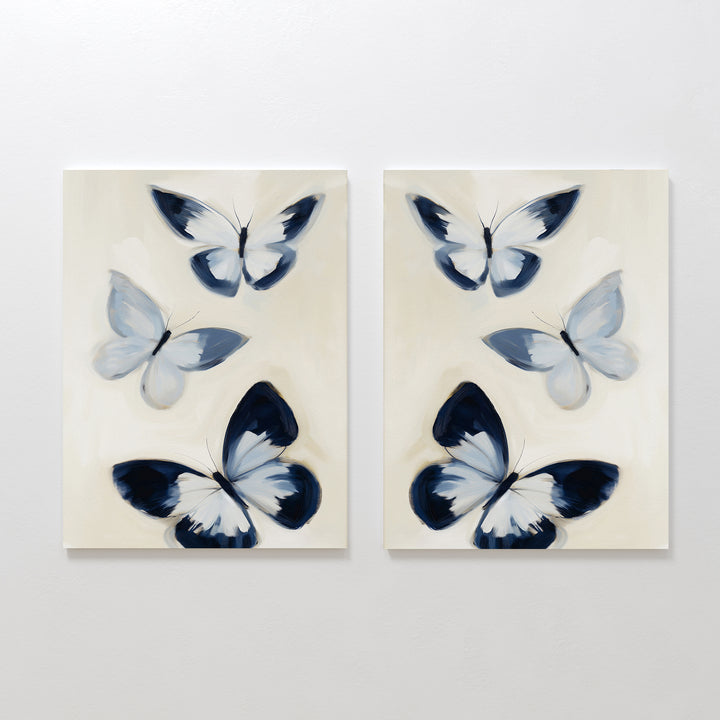 The Midnight Wings Set of 2 features abstract butterflies in soft blue, black, and white on beige canvas, bringing graceful movement and modern style to your wall decor.