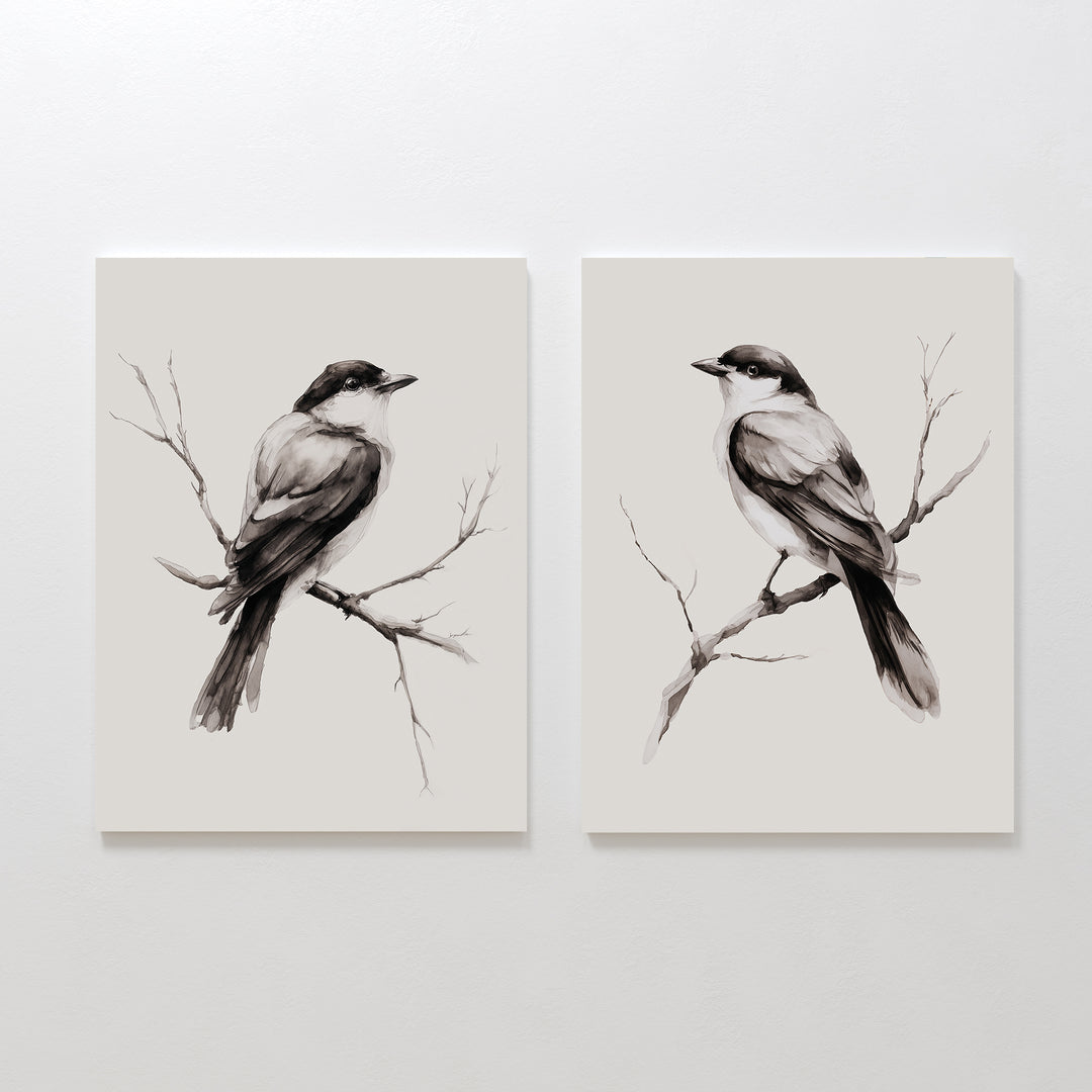 The Still Perch Set of 2 features minimalist black and white bird prints, each perched on a branch and facing opposite ways on a light backdrop. This neutral-toned wall art brings a touch of Nordic Park style to any space.