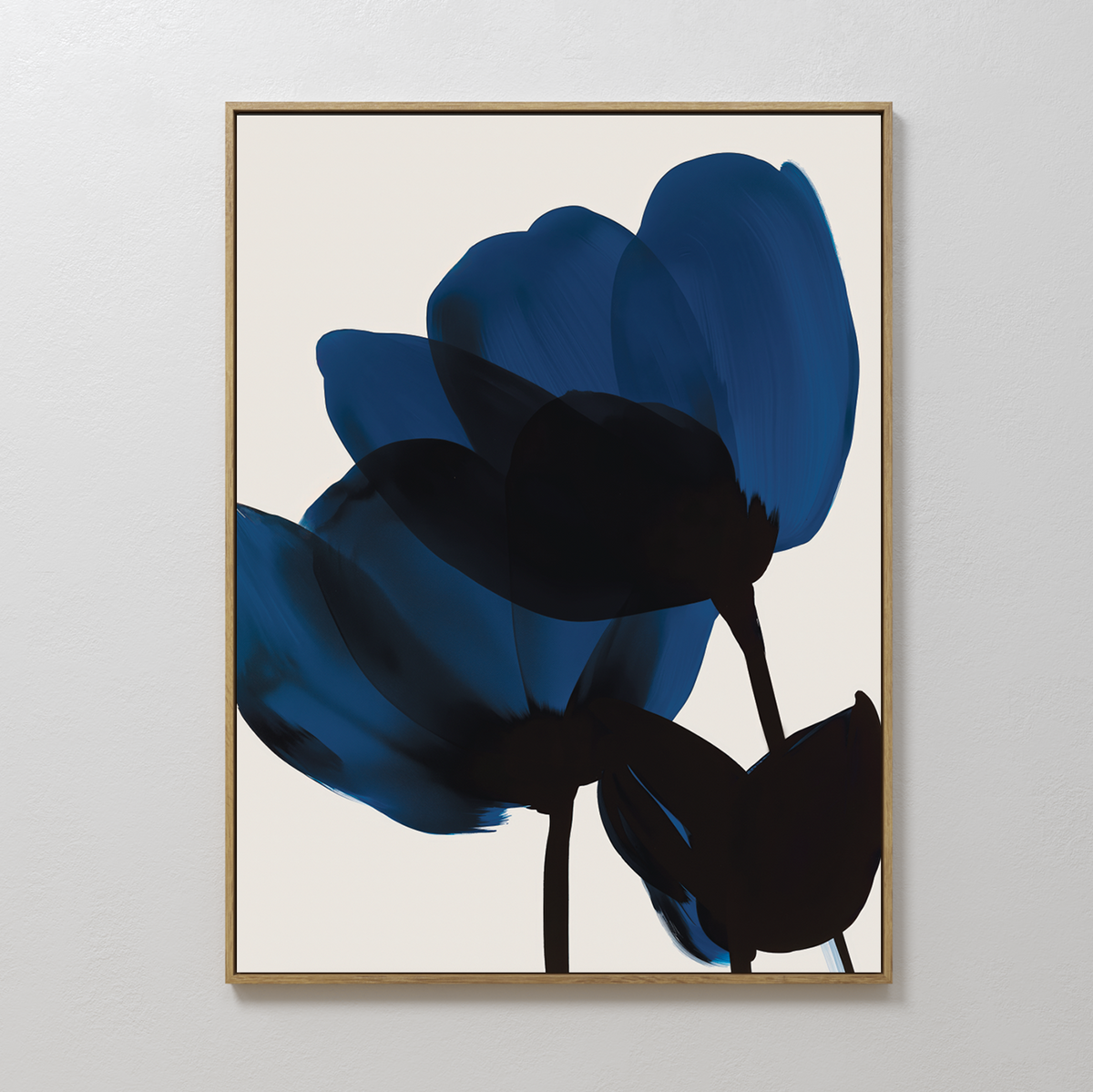 The Bloom Abstract Canvas Art features two dark blue abstract flowers with black stems on a light beige background, framed in thin gold—a perfect minimalist piece for modern living room decor.