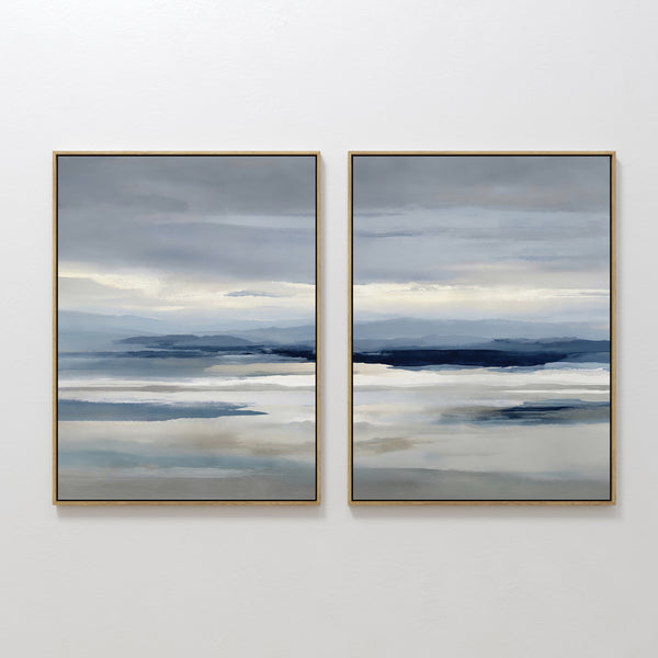 The Blue Mist Horizon Set of 2 features large abstract landscape prints in soft blue, grey, and beige. These framed canvases evoke a serene, cloudy sky, adding calming, minimalist decor to your living room when hung side by side.