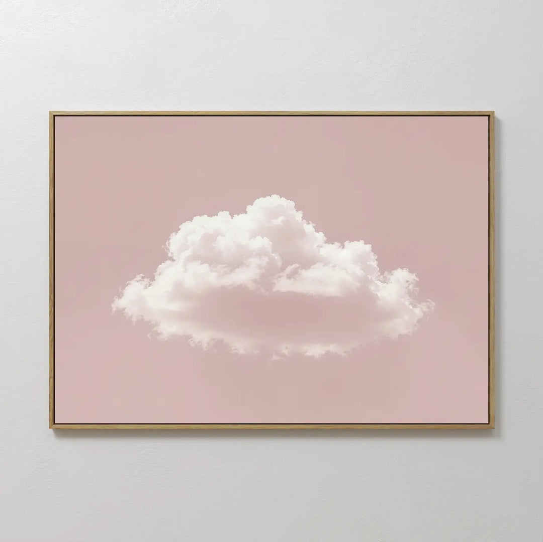 The Blushing Sky Canvas Art features a single fluffy white cloud centered on a soft pink background, adding minimalist charm to any space—perfect as bedroom wall art for light-colored walls.