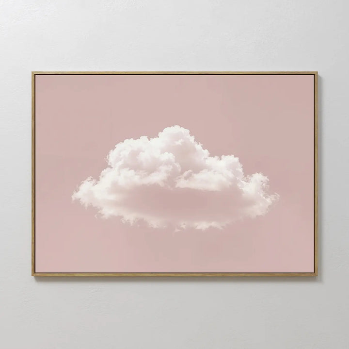 The Blushing Sky Canvas Art features a single fluffy white cloud centered on a soft pink background, adding minimalist charm to any space—perfect as bedroom wall art for light-colored walls.