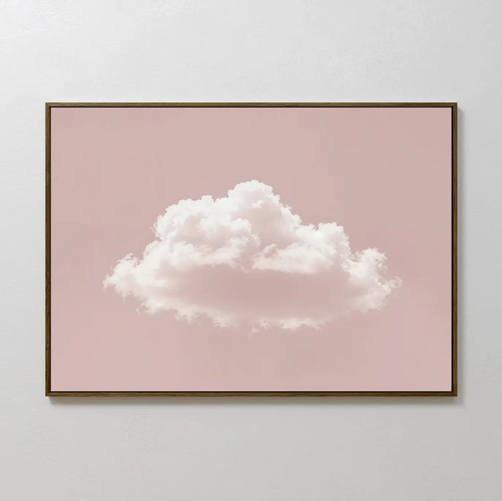 The Blushing Sky Canvas Art features a fluffy white cloud centered on a soft pink background—ideal for minimalist decor or as calming bedroom wall art. Display it on a light-colored wall for a serene touch.