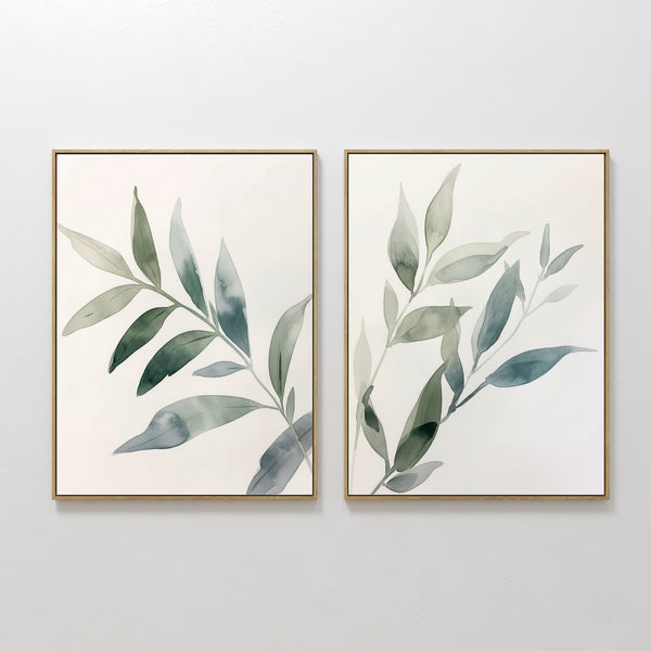 The Botanical Breeze Set of 2 features framed watercolor paintings of leafy branches in soft green and blue, displayed side by side. This minimalist wall art set brings a touch of nature to your decor.