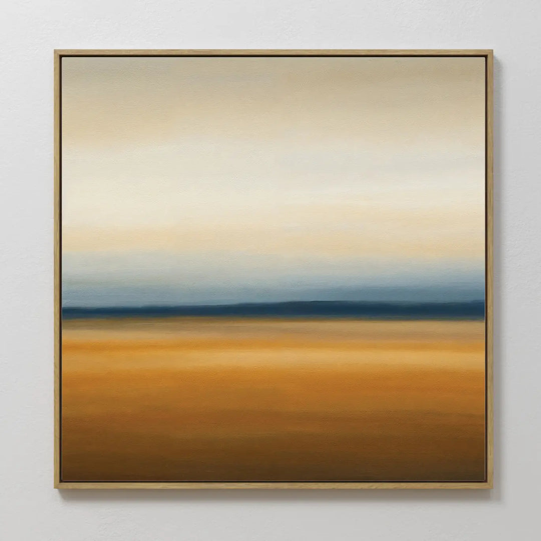 Caramel Plains Canvas Art features warm golden-brown layers, a blue-gray band, and soft white-beige tones, all framed in a slim golden frame—an ideal abstract wall art piece for modern bedroom decor.