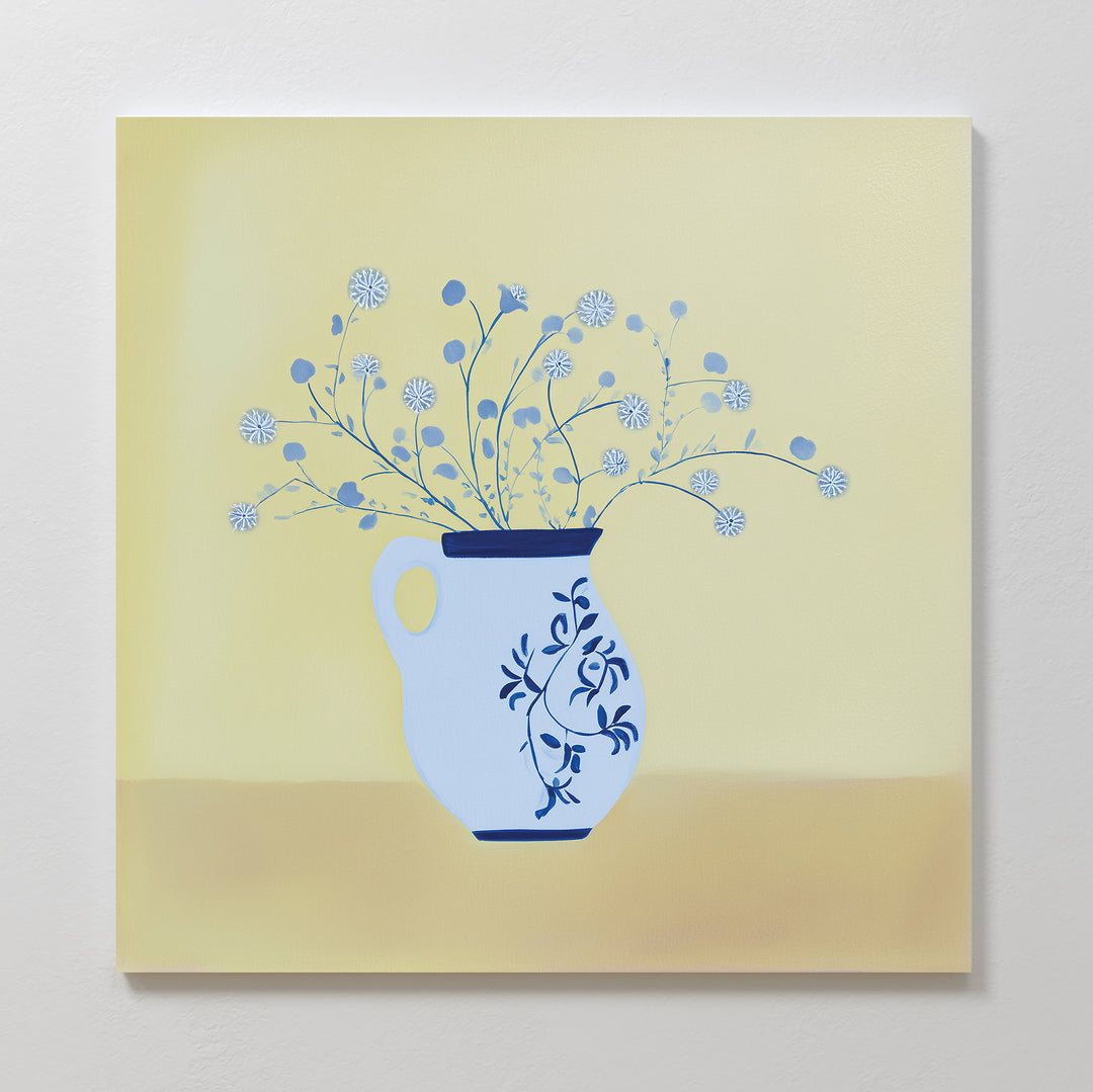 Cerulean Petals Canvas Art features a light blue ceramic pitcher with dark blue floral designs, filled with delicate blue and white wildflowers against a soft yellow background—ideal as minimalist wall decor or striking blue floral art.