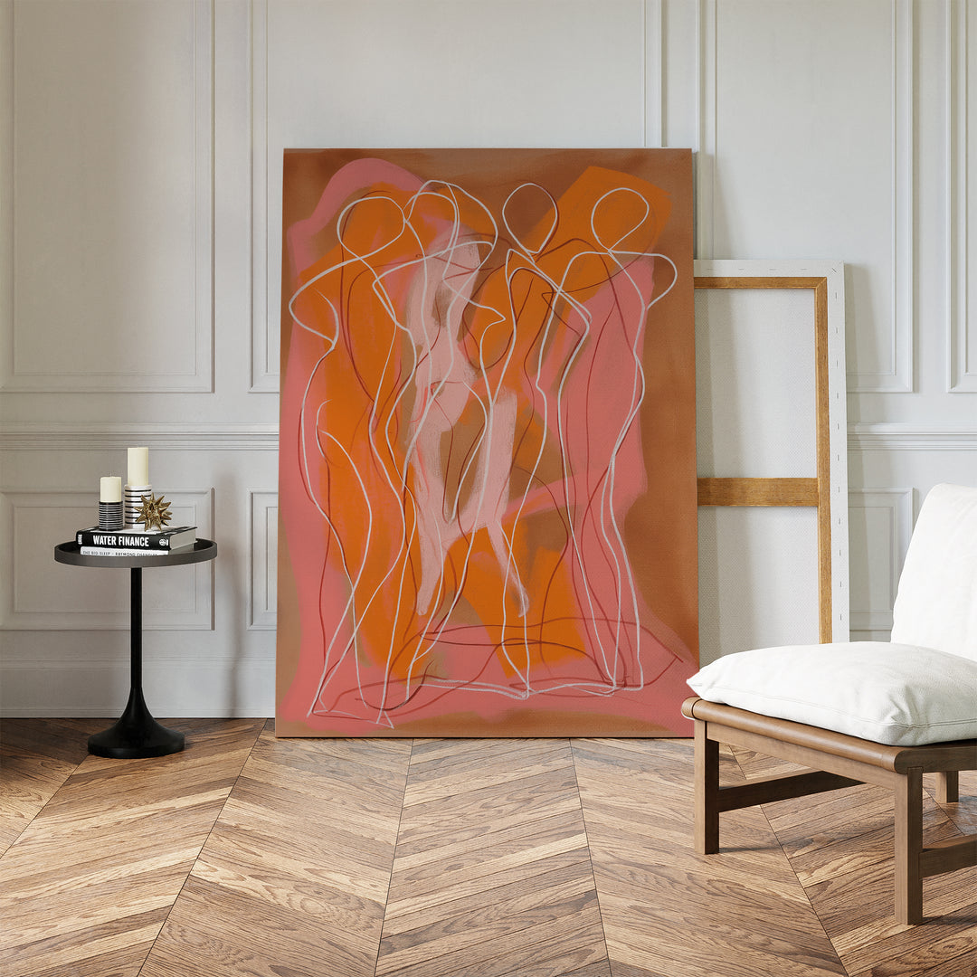 The Dancing Silhouettes Abstract Canvas Art, with pink, orange, and white silhouettes, leans against a white paneled wall. A round black table with candles and a white chair enhance this stylish living rooms herringbone floor.