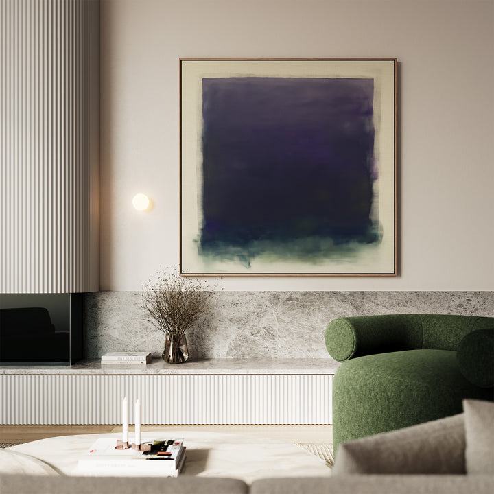 A modern living room with minimalist decor features the Deepest Night Canvas Art in dark blue and purple tones, a green upholstered chair, a marble shelf, a twig-filled vase, and neatly stacked books on a low table.