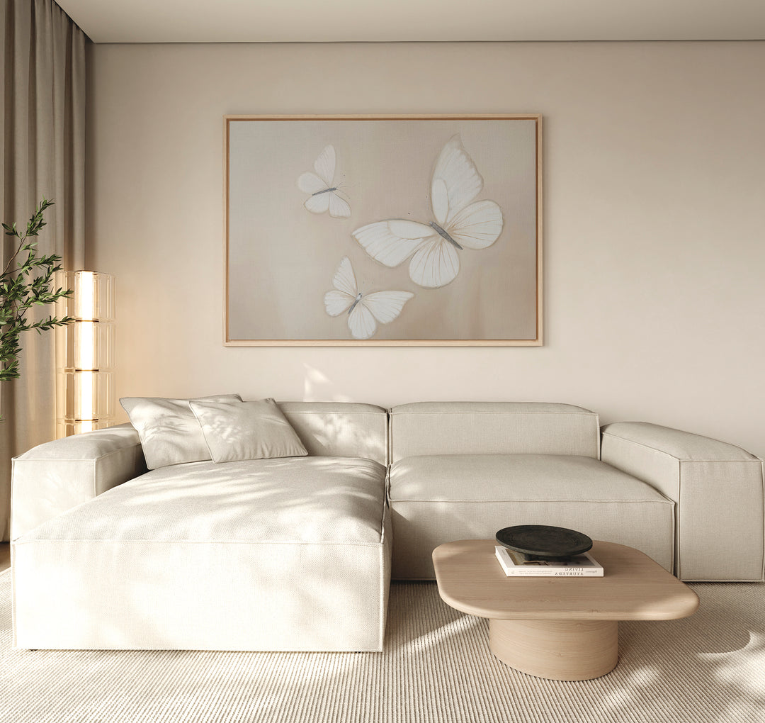 A modern living room with a light beige sectional sofa, low wooden coffee table, and the Delicate Whites Canvas Art. Soft natural light fills the Nordic Park-inspired space, enhancing its neutral tones and minimal decor.