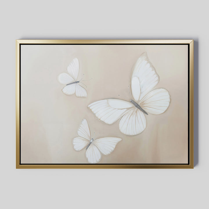 The Delicate Whites Canvas Art displays three white butterflies with delicate wings on a light beige background, elegantly framed in gold—a stylish piece of neutral wall decor.