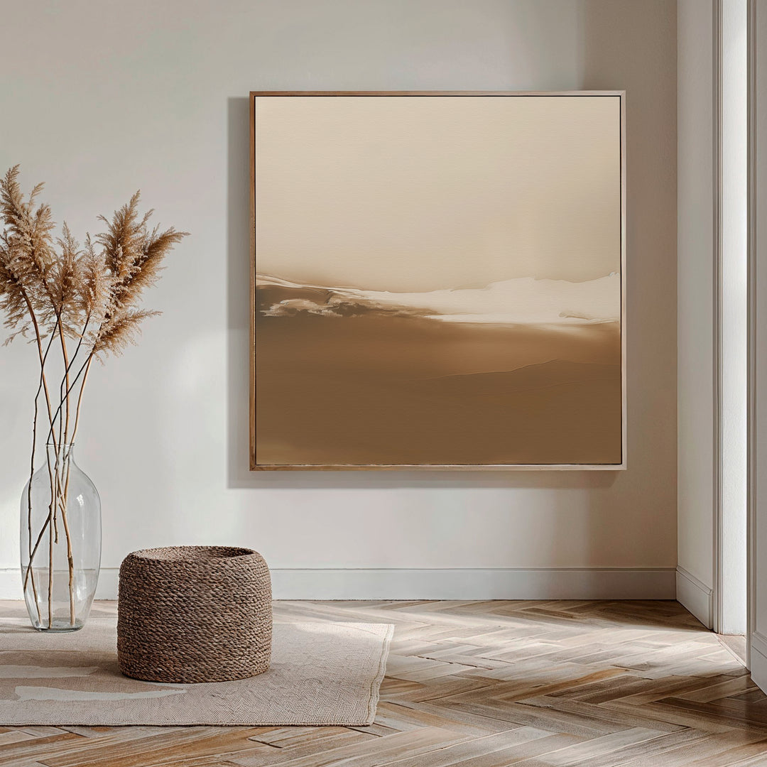A minimalist living room features Desert Dusk Abstract Canvas Art, a glass vase with dried pampas grass, a woven basket, and wooden herringbone flooring, all in neutral tones.