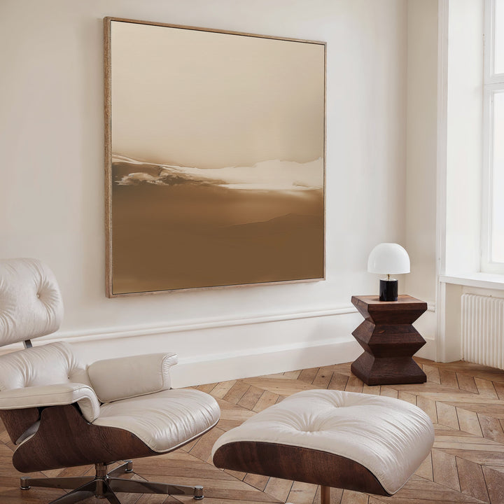 A modern, minimalist room with a cream lounge chair, wood side table and round lamp, featuring the Desert Dusk Abstract Canvas Art above. Light herringbone floors and tall windows complete the Nordic Park-inspired space.