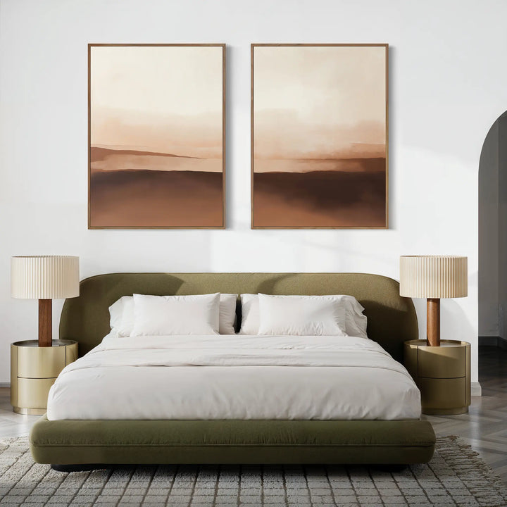 A modern bedroom features an olive green bed, white bedding, round beige nightstands with matching lamps, and the Desert Landscape Set of 2 minimalist prints above the bed on a white wall. A textured rug finishes this neutral interior.