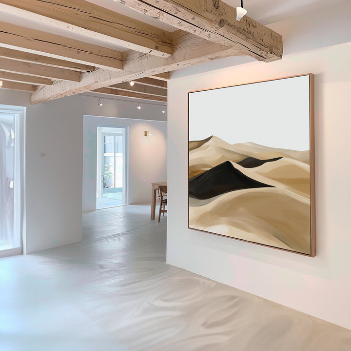 A modern, minimalist interior with white walls and wooden beams features the Dune Waves Abstract Canvas Art—an abstract painting of sand dunes in beige, brown, and black—perfect for contemporary living room decor.