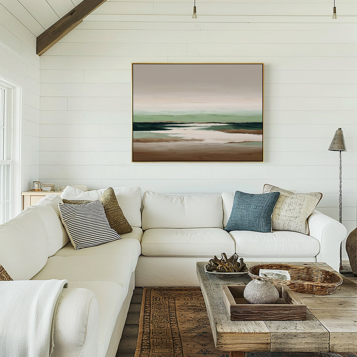 A cozy living room with a white sectional sofa, assorted throw pillows, a rustic wooden coffee table, and the Earthbound Horizon Canvas Art as large wall decor on the white shiplap wall. Natural light streams in from a window.