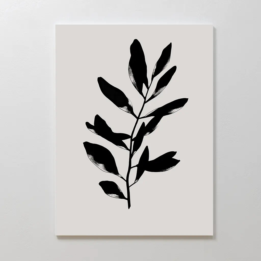 Ebony Leaf Canvas Art: A minimalist print featuring a bold black leafy branch silhouette on a white background. This botanical wall art adds simple elegance and modern style to any interior.