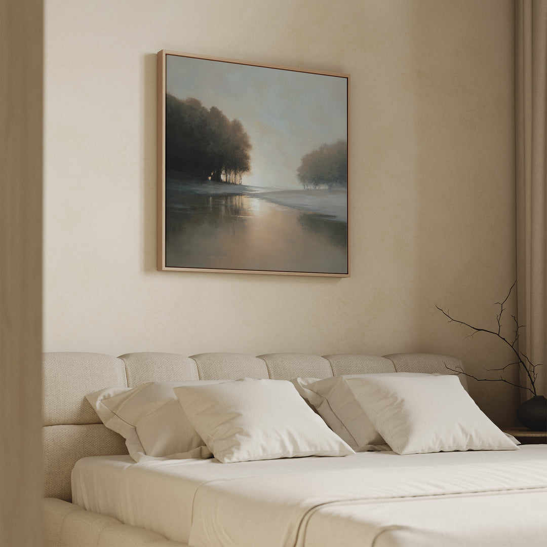 A serene bedroom features a beige upholstered bed with white bedding and pillows, accented by the Ember Shore Canvas Art above the headboard. Soft natural light enters from the side, creating a calm and inviting atmosphere.