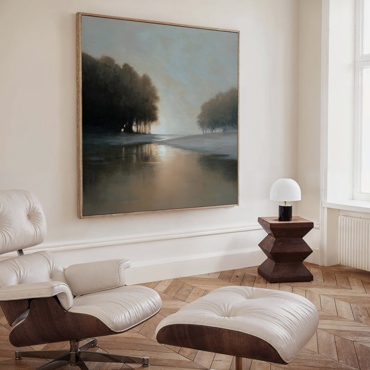 A modern living room with a white leather lounge chair and ottoman, a dark wood side table with a white lamp, and the Ember Shore Canvas Art creates refined living room decor.