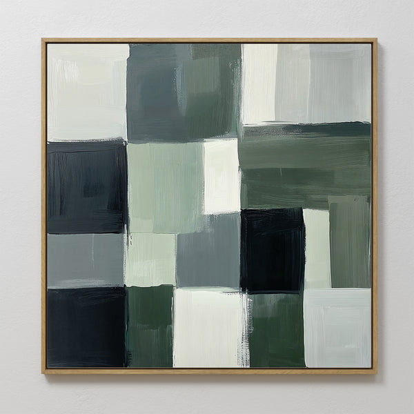 The Evergreen Abstract Canvas Art features a grid of overlapping rectangles in muted green, black, gray, and white with visible brushstrokes and uneven edges. Framed in simple wood, it’s perfect modern wall art for any space.