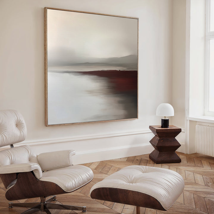A modern living room with a white leather lounge chair and ottoman, a wooden side table with a white lamp, and the Fading Light Canvas Art as striking landscape wall art in muted tones.