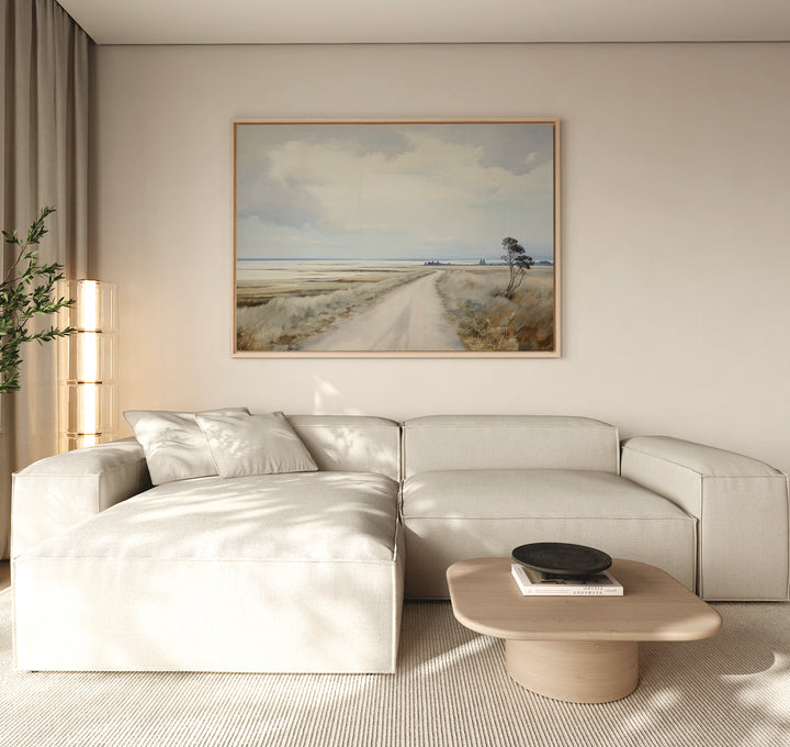 A modern living room featuring a light beige sectional sofa, minimalist decor, a wooden coffee table with a black bowl, a potted plant, and the Far Light Canvas Art displayed above the sofa.
