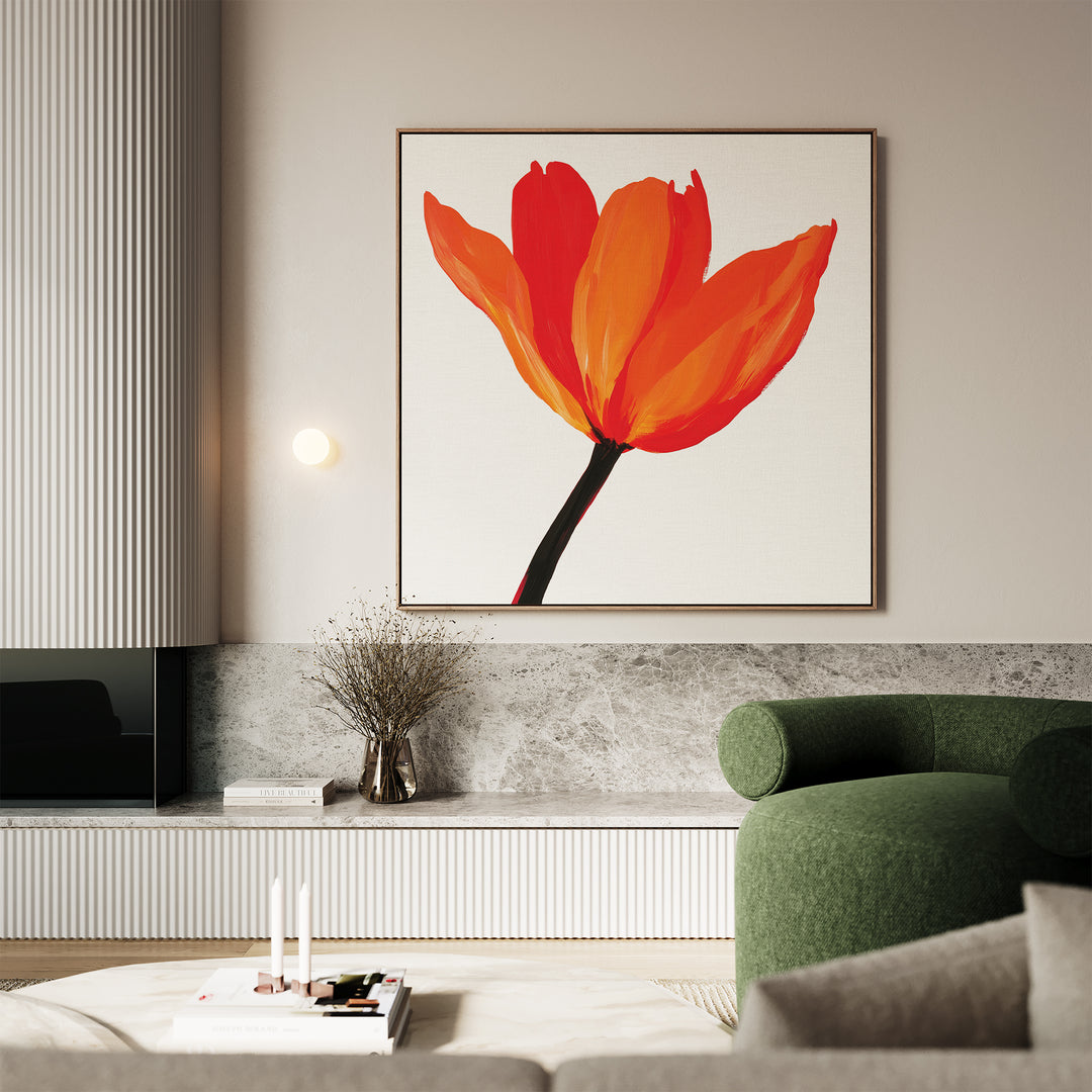 A modern living room showcases Flame Tulip Canvas Art above a gray marble shelf, paired with a green armchair, a branch-filled vase, and neatly stacked books on a white coffee table for chic decor.