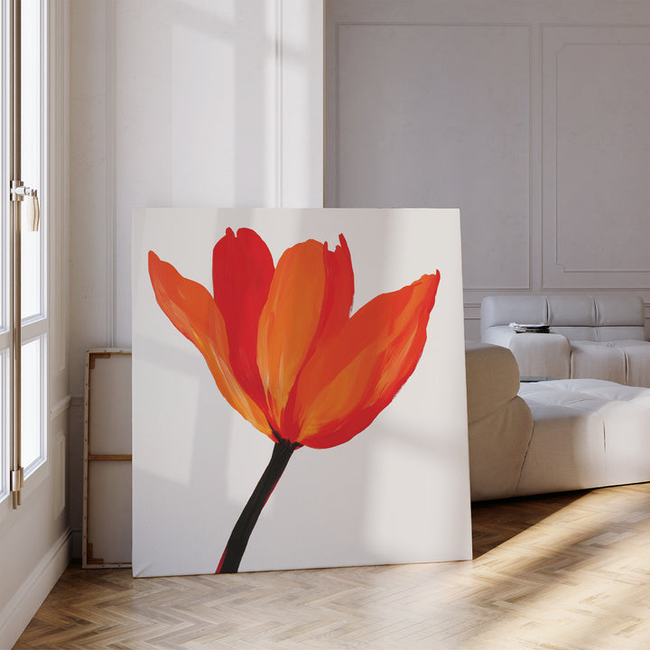 The Flame Tulip Canvas Art, featuring vivid red and orange petals with a dark stem, adds minimalist floral decor to a modern living room, ideal beside a white sofa and sunlit windows.