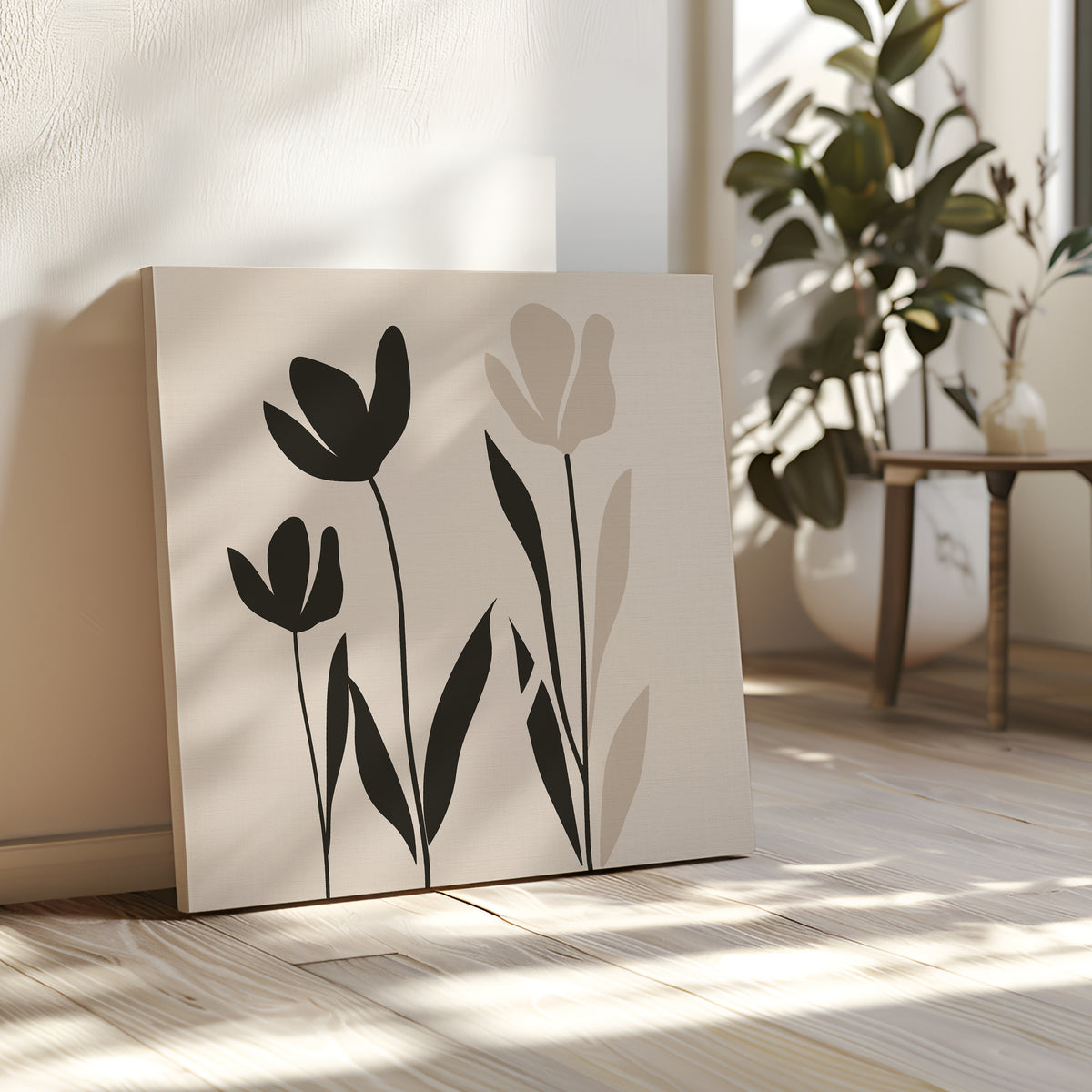 The Floral Simplicity Canvas Art, featuring black and beige tulip silhouettes, leans against a white wall on a sunlit wooden floor, bringing subtle elegance to vintage-inspired decor next to a potted plant and small table.
