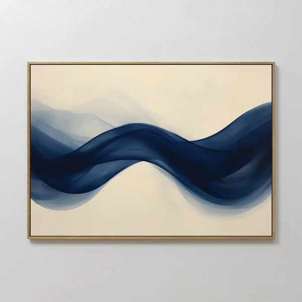 Flowing Indigo Canvas Art features a ribbon-like wave in deep blue on a light beige background, framed in slim gold—ideal modern wall art to enhance minimalist spaces or add style to your living room decor.
