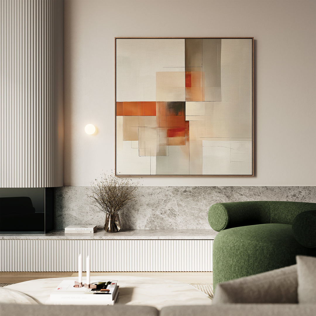 A modern living room features a green armchair, marble surfaces, minimalist decor, a vase with dried flowers, and Fractured Light Canvas Art—a large abstract piece with orange, beige, and gray geometric shapes—on the wall.