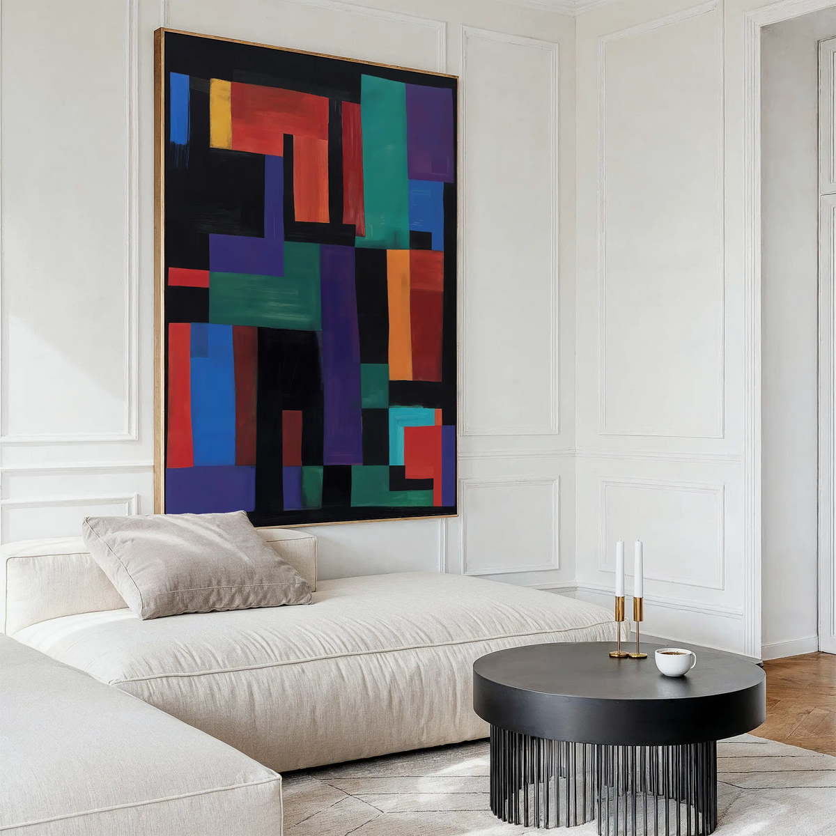 A modern living room features a white sectional sofa, beige pillow, black round coffee table, and the Geometric Mosaic Canvas Art—abstract wall decor with bold red, green, blue, and purple geometric shapes.