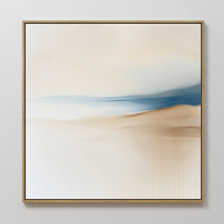 Golden Drift Canvas Art features minimalist abstract design with soft beige, white, and blue hues blending in serene gradients. Framed in a slim light wood frame, it’s perfect for adding an elegant touch to your living room’s white walls.