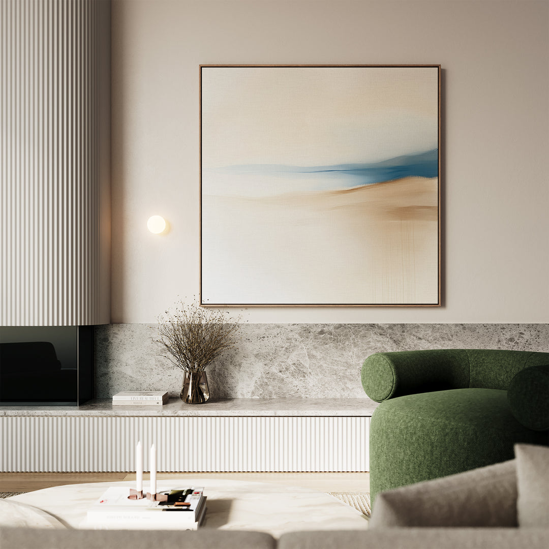 A modern living room with a green armchair, marble console, candles, books, a vase with dried branches, and the Golden Drift Canvas Art in beige and blue—perfect inspiration for stylish living room decor.