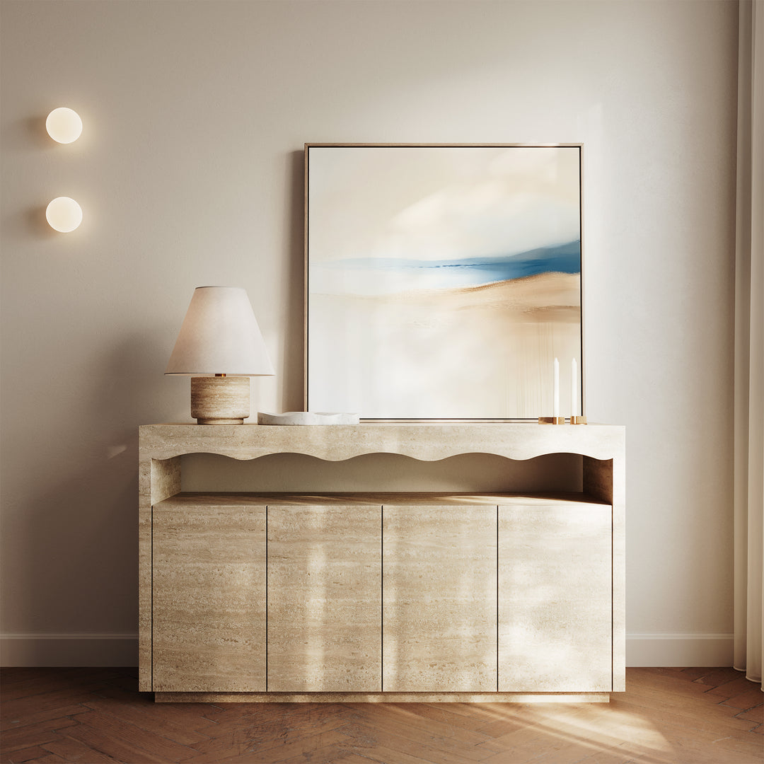 A minimalist sideboard holds a lamp, two candles, and the Golden Drift Canvas Art in beige and blue, set against a neutral wall with round lights—perfect for modern living room decor.
