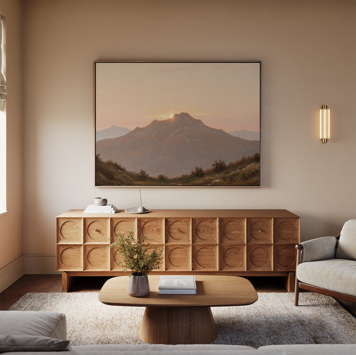 A cozy living room features a wooden coffee table, textured sideboard, and the Golden Summit Canvas Art of mountains at sunset above the sideboard. A sofa and a small vase with flowers complete this serene space.