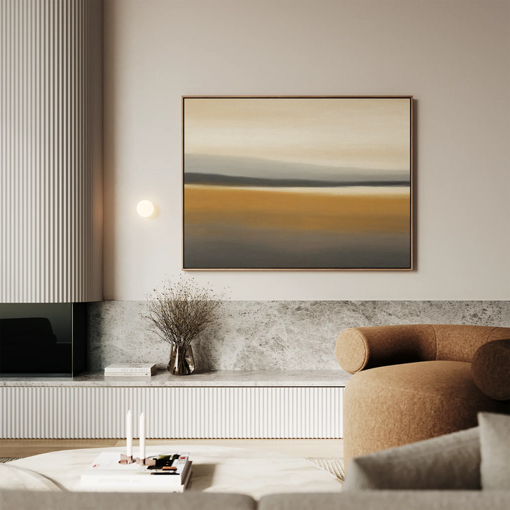 A modern living room with neutral tones features the large Honey Mesa Canvas Art, a round brown armchair, a marble shelf, a vase with dried branches, and soft ambient lighting—perfect for fans of modern decor.