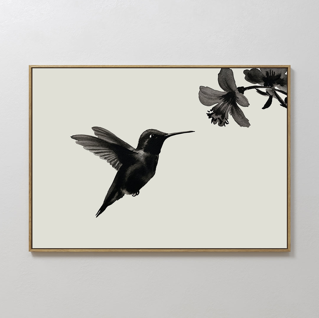 Hummingbird Motion Canvas Art features a minimalist black hummingbird in flight near a flower, set on a light background with a thin frame—ideal for modern decor and minimalist wall art collections.