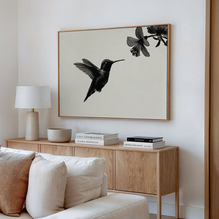A minimalist living room features a wooden sideboard, modern decor, and the Hummingbird Motion Canvas Art as bold wall art above, creating a serene and stylish atmosphere.