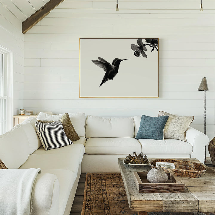 A cozy living room featuring a white sectional sofa, patterned pillows, rustic coffee table, and the Hummingbird Motion Canvas Art as minimalist wall decor on shiplap walls adds a chic touch to this inviting space.