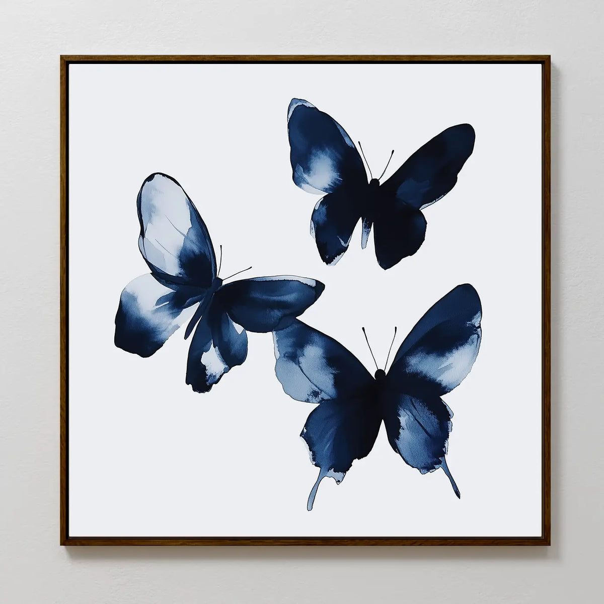 The Indigo Flutter Canvas Art features three dark blue abstract butterflies with open wings on a white background, created with delicate, fluid brushstrokes—an ideal addition to modern home decor.