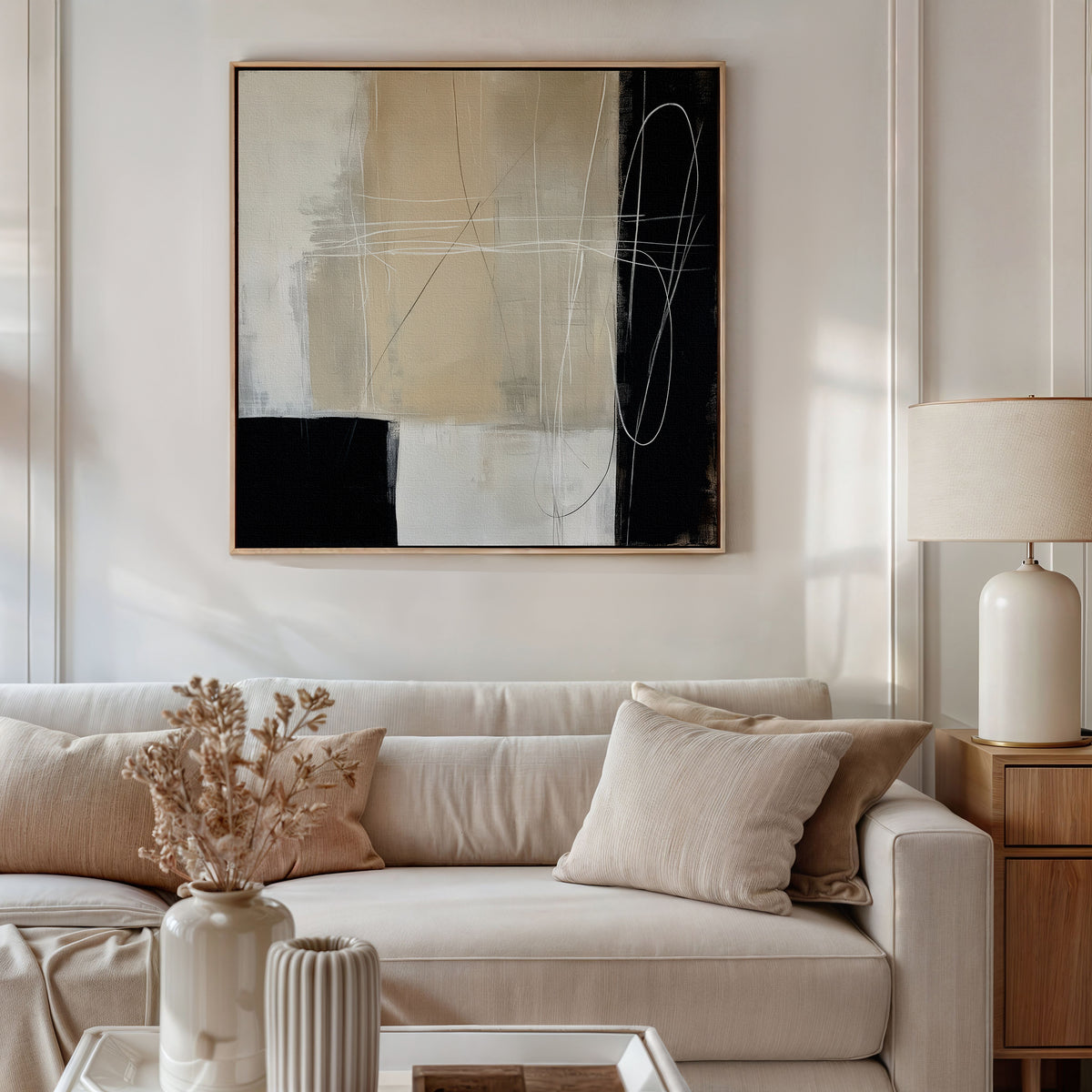 A modern living room features a beige sofa, neutral cushions, a wooden side table with a ceramic lamp, dried flowers on the coffee table, and Light and Shadow Abstract Canvas Art as the striking focal point of the decor.