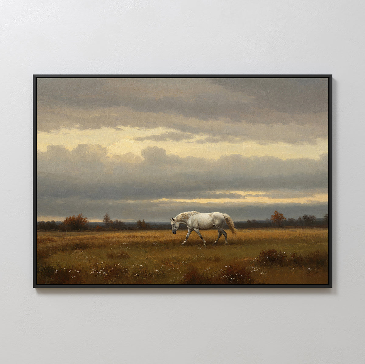 The Low Light Walk Canvas Art features a framed wall print of a white horse walking alone in a grassy field beneath a cloudy sky, with trees and gentle light along the horizon.