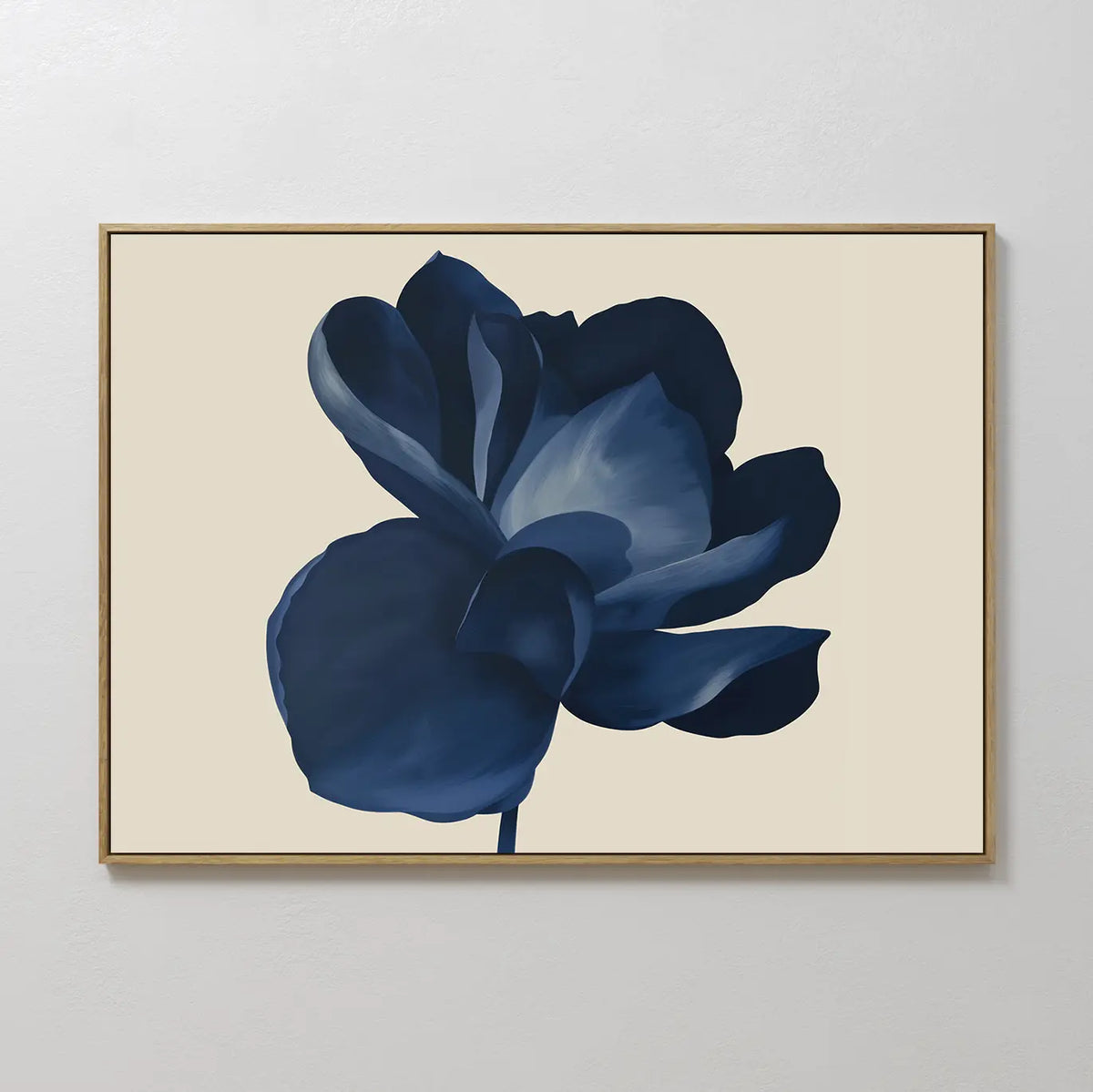 The Midnight Bloom Canvas Art – Horizontal features a large blue flower with soft, layered petals on a beige background, adding modern sophistication to minimalist spaces when displayed on a white wall.
