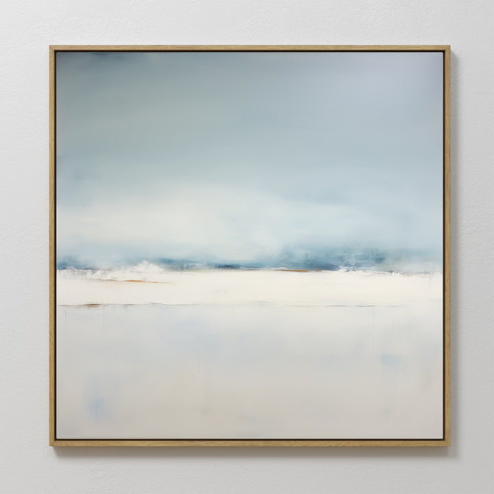 Misty Morning Abstract Canvas Art features soft blue and white tones in a minimalist landscape, evoking a serene sky over snowy ground. Framed in wood and hung on a white wall, it’s perfect for tranquil home decor.