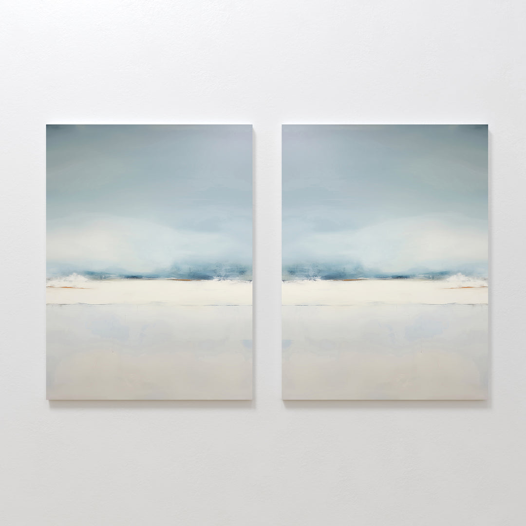 The Misty Morning Set of 2 features minimalist wall art in soft blue, white, and beige tones, hung side by side. Each piece evokes a tranquil mood with blurred horizontal landscapes reminiscent of a serene Nordic park.