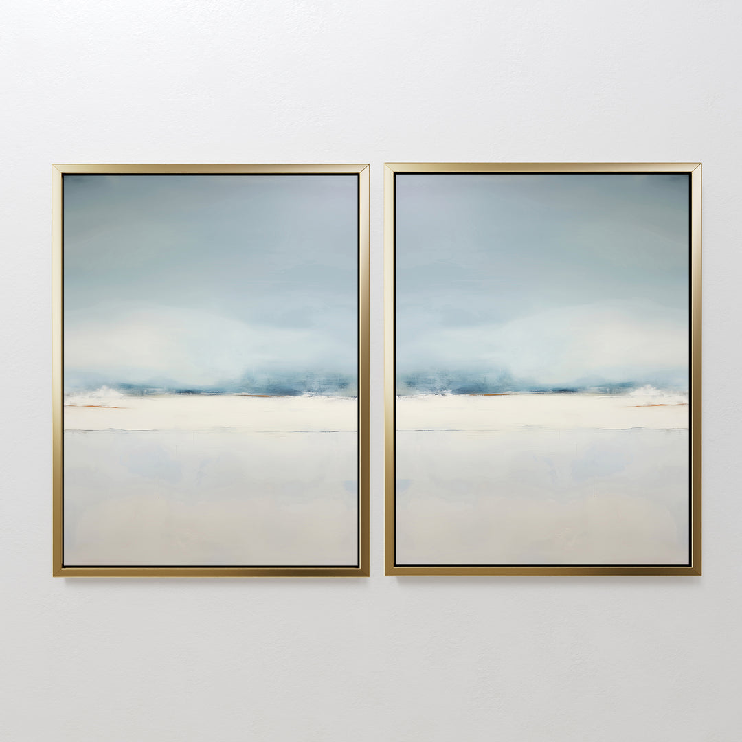The Misty Morning Set of 2 features framed abstract art in soft blue, white, and beige tones. Their minimalist design with mirrored horizon lines evokes serene seascapes or landscapes, creating a tranquil atmosphere on any white wall.