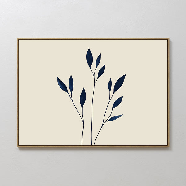 Navy Stem Canvas Art features thin black stems with solid navy blue leaves on a beige background, framed in slim wood and displayed on a white wall for striking, modern minimalist decor.